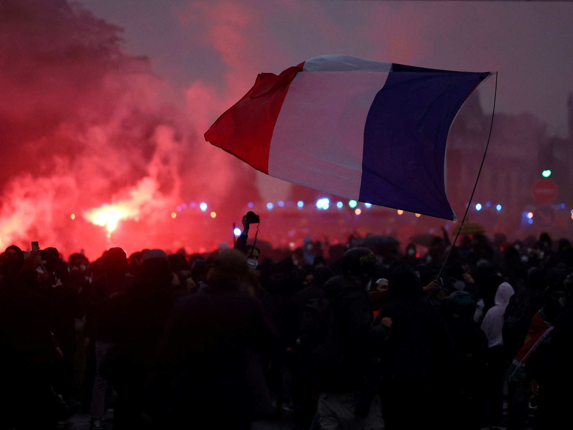 Manifestantes llevan una bandera de Francia mientras un grupo se enfrenta con la policía en la marcha del sábado pasado en París